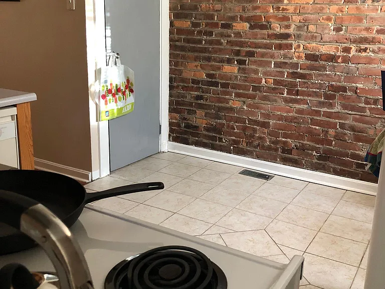 Exposed brick eat in kitchen and door down to private basement