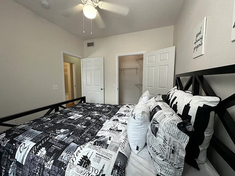 Cozy bedroom featuring modern black and white decor, with plush bedding and ample closet space. Cozy bedroom featuring modern black and white decor, with plush bedding and ample closet space.
