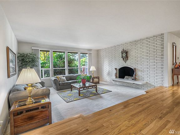 The gracious formal lounge, located just off the entry foyer, features a dramatic brick wall with cozy wood-burning fireplace. Extensive windows provide a backdrop of natural beauty.