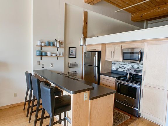 Kitchen with open shelving stainless steal appliances