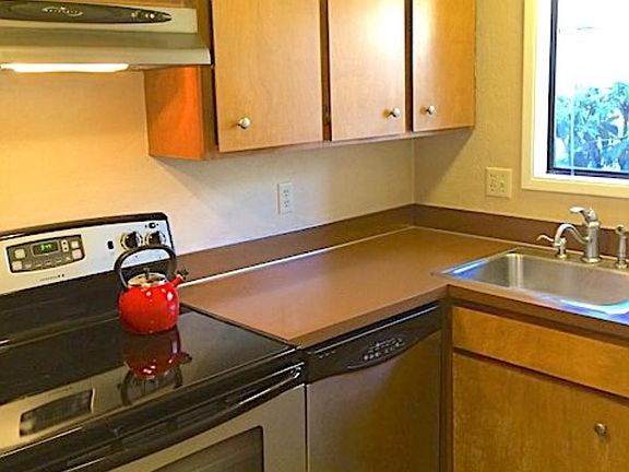 Kitchen with stainless steel dishwasher, stove and refrigerator.