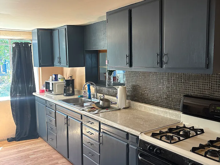 Freshly painted kitchen cabinets with new tile backsplash and new kitchen faucets