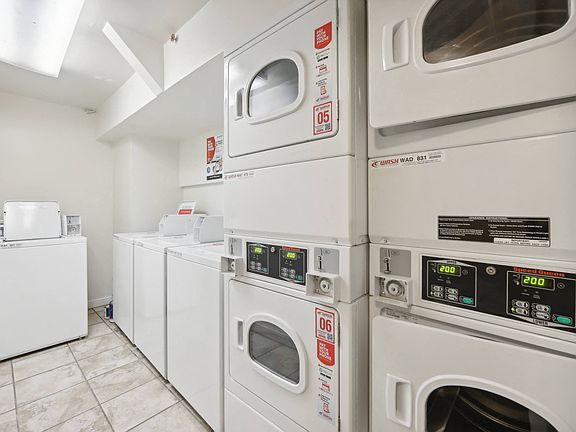 Laundry room with washing machines neatly arranged on a wooden floor