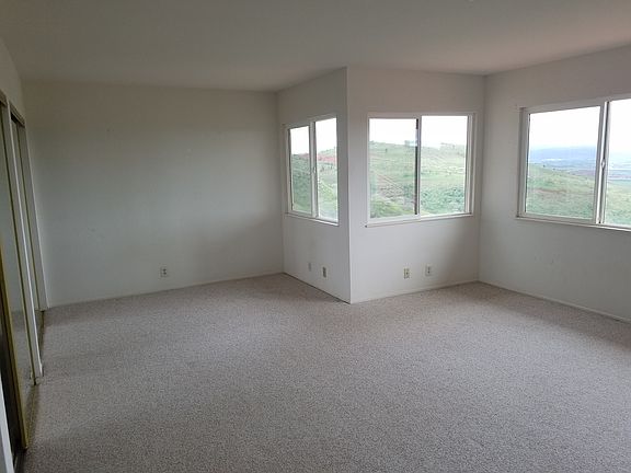 Standing at the wall next to the sink, looking across the room. See the hillside out the windows.