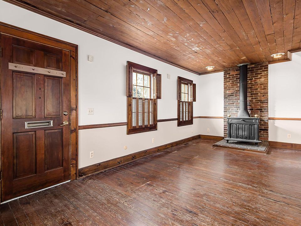 Living room with wood-burning stove and wood shutters.