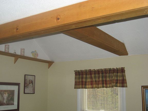 beams shelving and cathedral ceiling in living room