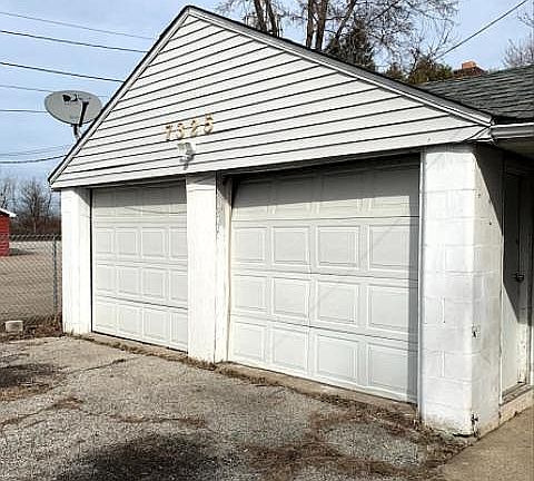 2 and half car garage with another roll up door on back that leads to enormous back yard.