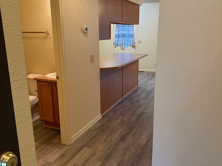 Hallway leading to laundry room, living room, kitchen.