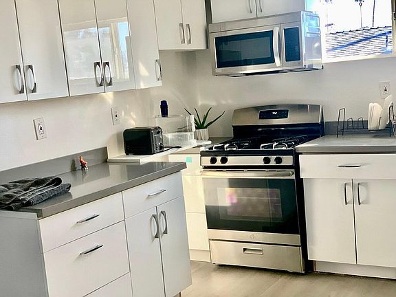 Kitchen with new cabinets, microwave, oven. Sink and dishwasher to right (not pictured)
