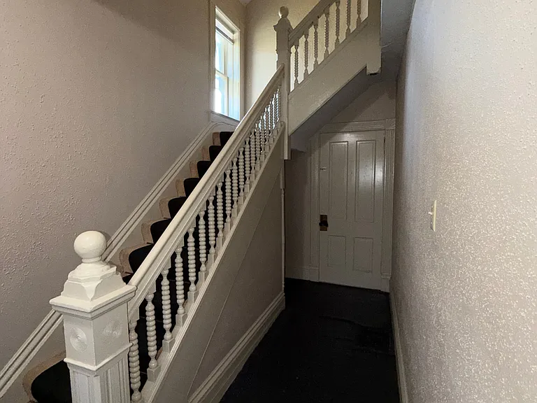 entry area with shelves under stairs