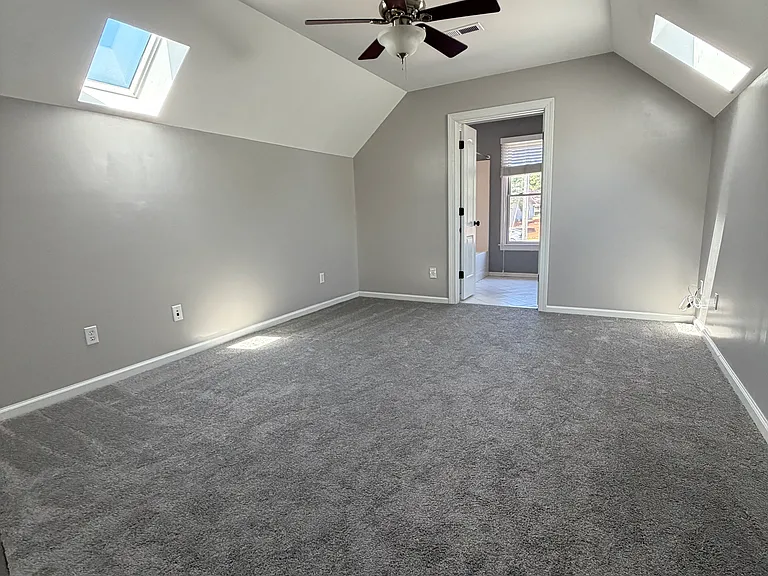 Bright second bedroom with a skylight that floods the room with soft natural light, plus direct access to a full bath_perfect for guests, a home office or a quiet retreat with airy, vaulted vibes.
