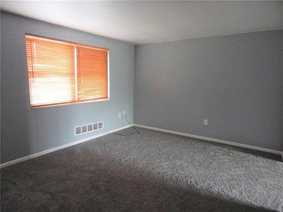 FRESHLY PAINTED LIVING ROOM WITH NEW WALL TO WALL CARPETING.