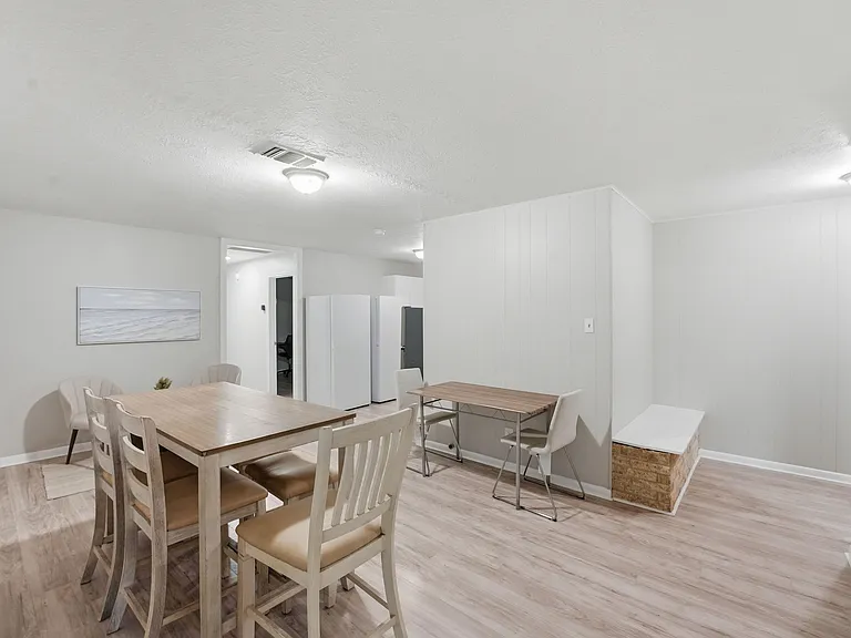 Open dining area with wood-look flooring, space for a full table, and an adjacent nook ideal for a desk or extra seating.