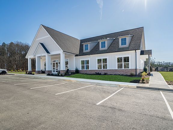 Clubhouse exterior with ample parking and rocking chairs on the front porch.