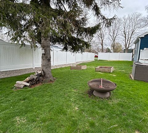 Partially fenced in yard with built-in garden boxes