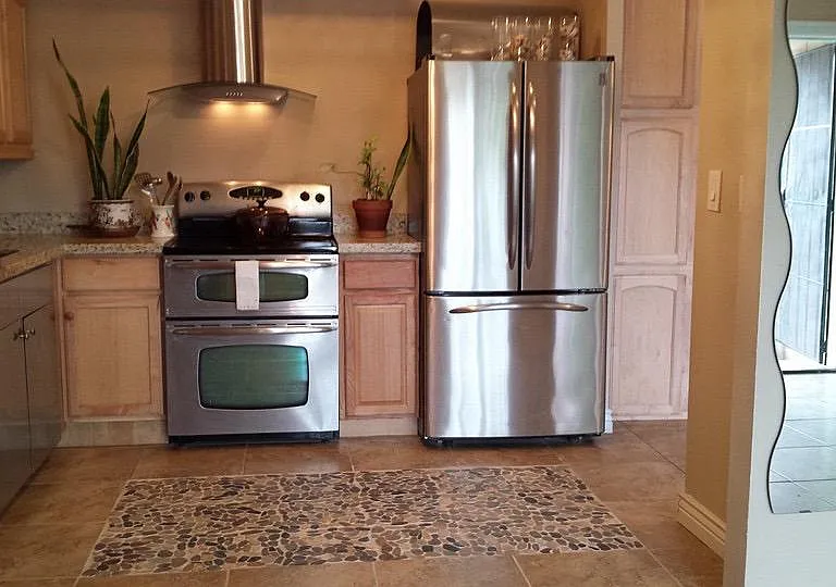 Kitchen with tile flooring and rock design flooring. Granite countertops.
