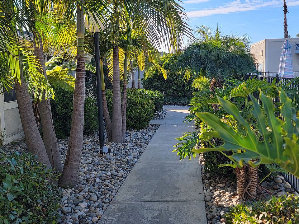 Lush garden pathway between buildings at the Presidio Villa Apartments in Vista, California.