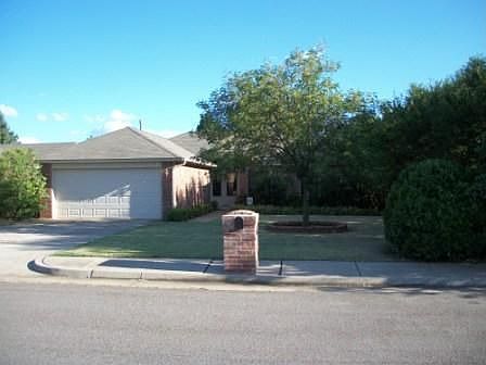 Brick mailbox & large shrubs conceiling school