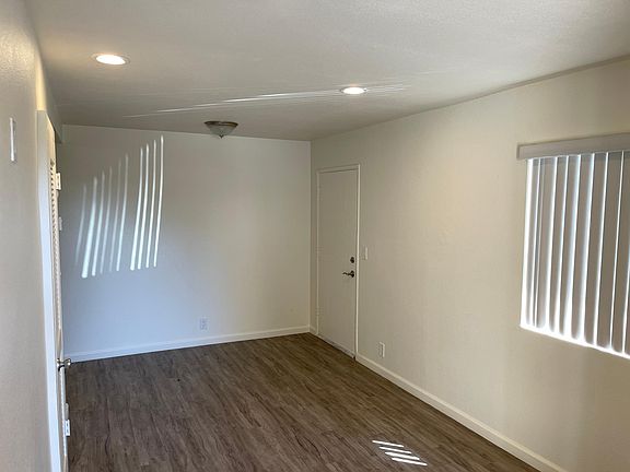 Living room with recessed lights and newer floors.