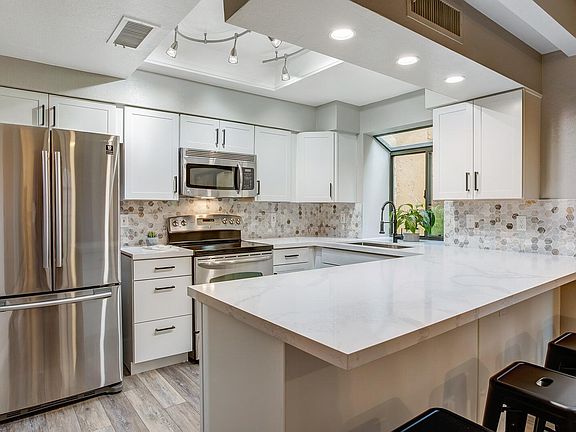 Updated kitchen with White Cabinets, Carrara Quartz countertops, stainless steel appliances and Marble backsplash!