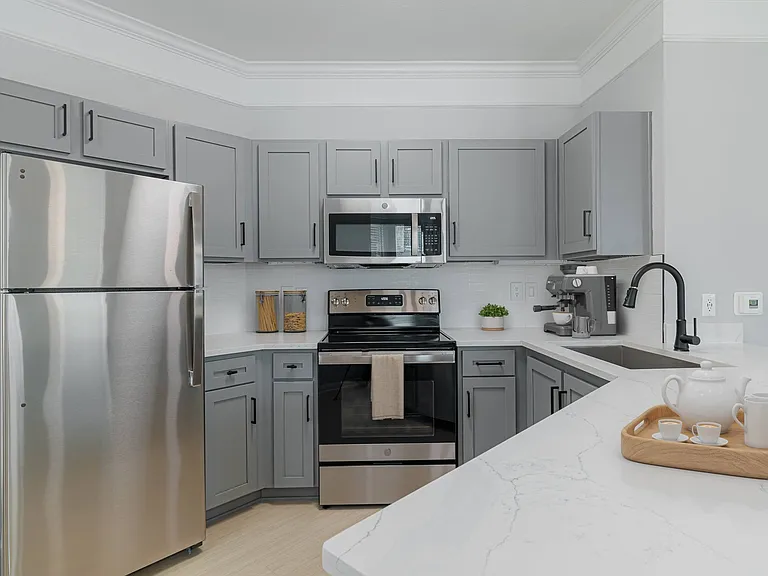 Renovated kitchen with granite countertops, farmhouse sink, stainless steel appliances, and modern gray cabinetry