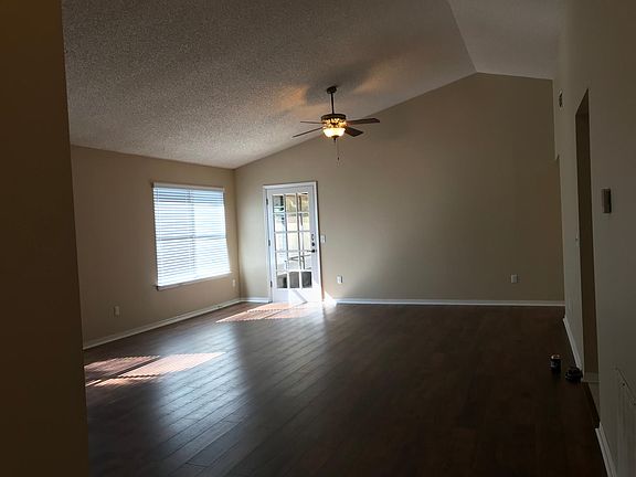 Family room with vaulted ceilings leads out to back porch.