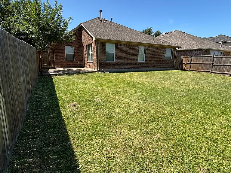 Standing at back fence looking at house.