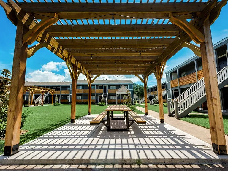 Covered pergola with shaded seating and community outdoor amenities