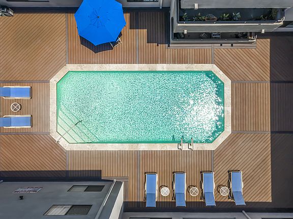 Apartments in Valley Village, CA - Aerial View of Pool, Patio with Lounge Chairs Umbrellas Table and Chairs