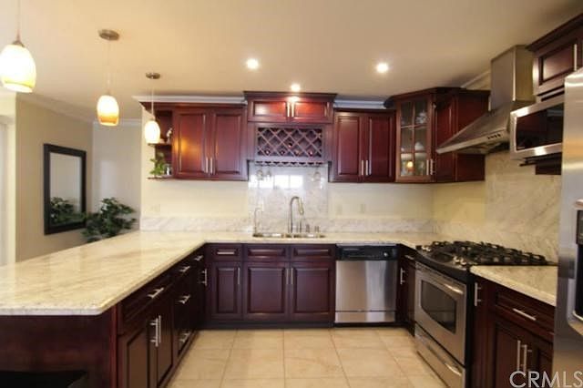Beautiful kitchen with granite countertop, cherry wood cabinets, stainless appliances, recess lights