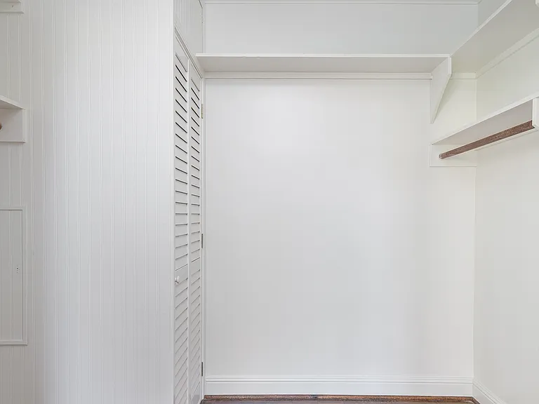 Additional walk-in closet adjacent to living room. Stacking washer/dryer behind louvered doors.