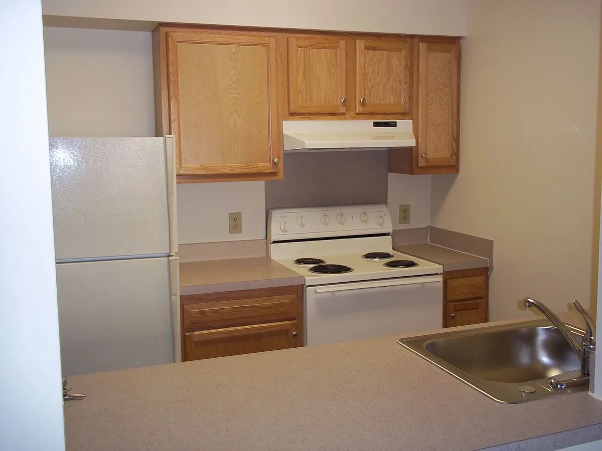 Kitchen With Wooden Cabinets - Schoolhouse Apartments CT
