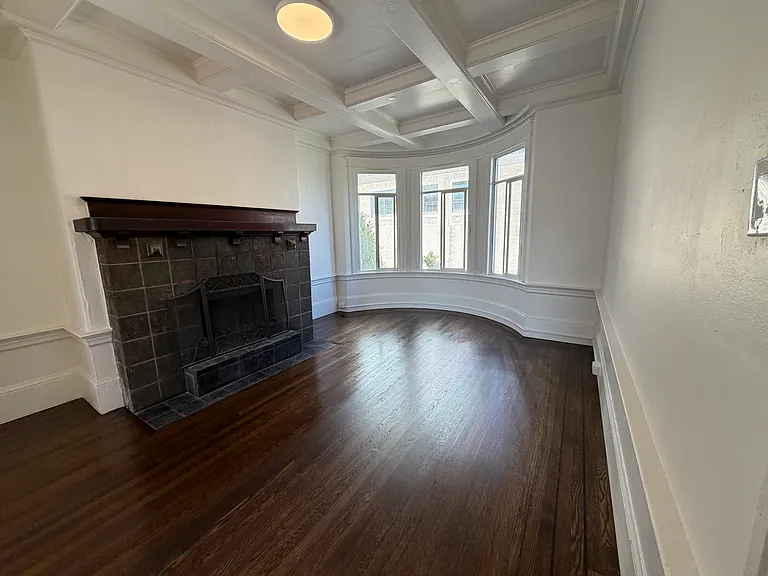 Living room with box ceiling. Entire unit is freshly painted and floors refinished.