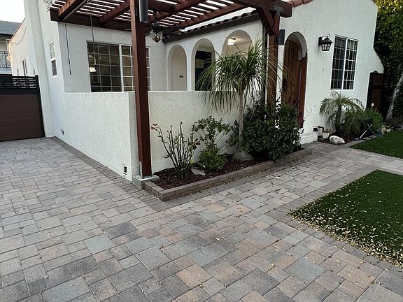 Pergola over outdoor patio with fan and shades