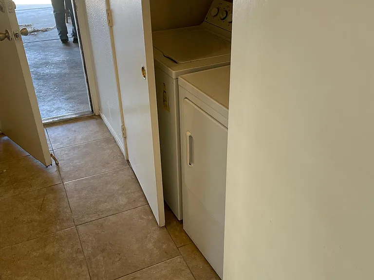 Washer on dryer inside . In hallway to attached garage