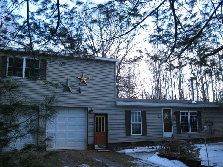 Country location with a cottage decor. Well kept 3 bedroom home with room to spread out. There is a newer stick built addition of an attached heated garage with a second story, which can be an ideal master bedroom or family room. Home is west of Midland, giving easy access to M-20. Kitchen is open with raised panel cabinets, a newer stove, corner windows for a treed view.  3 acres to enjoy nature and get away from it all. Beautiful soap stone radiant heat wood burner in the living room, ceramic floors to keep the home toasty and save on the LP gas. A years supply of wood is included. The additon has its own efficient gas wall furnace unit that uses minimal utilities. Fenced yard for the little ones, and city water at the road. 
