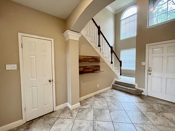 Stairs on the right hand side entering the house and powder room under stairs