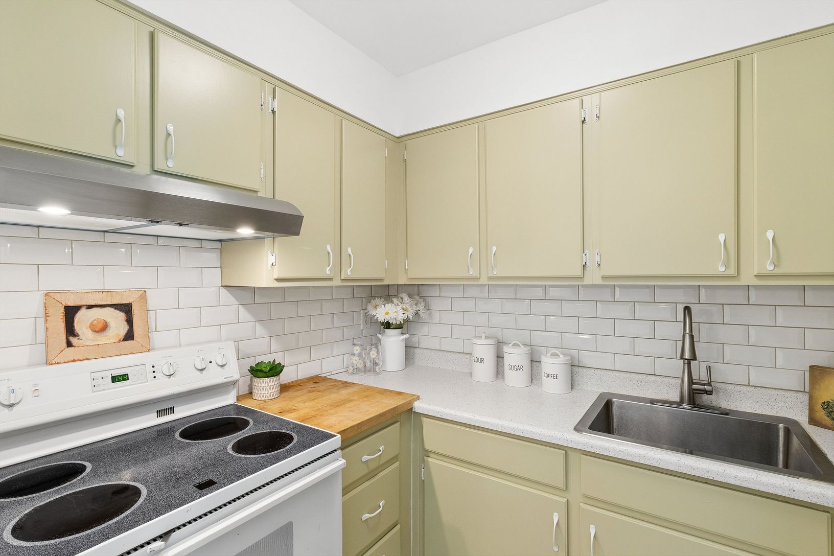  Kitchen, freshly painted, new hood vent, classic subway tile and stainless sink.