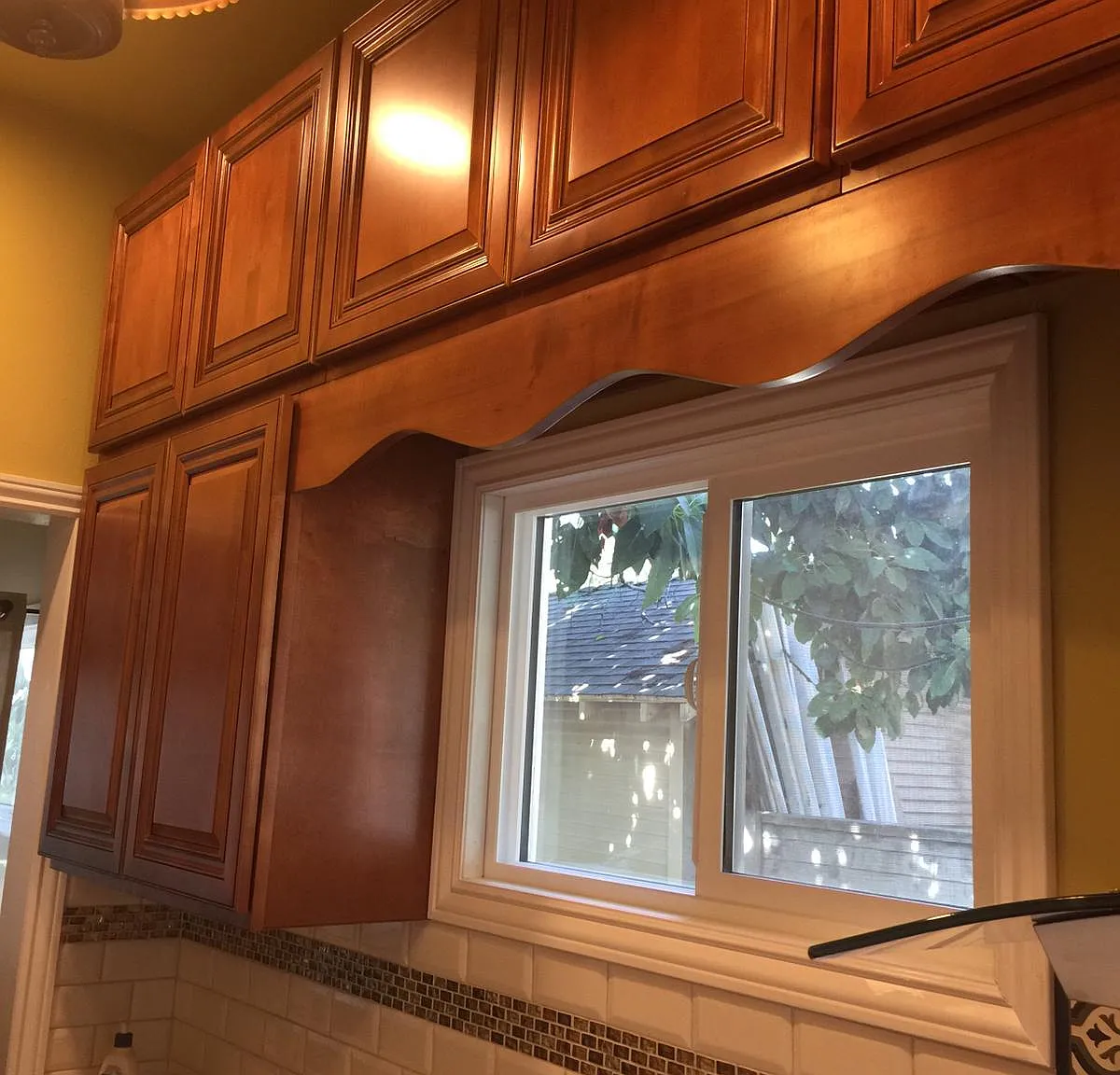more detail of countertop/backsplash just inside entry on right side and cabinetry and windows for good daylight