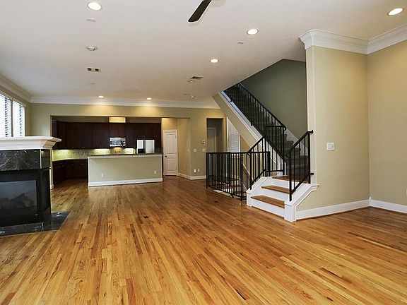 Spacious open floor plan features fireplace and hardwood floors.