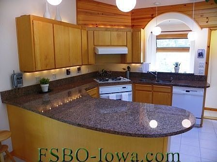 Kitchen is bright and spacious, with granite counters and custom Amish-built maple cabinetry.