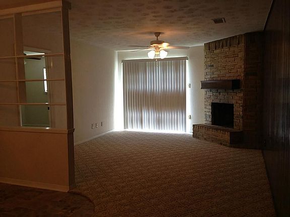 Another view of living room with ceiling fan from entry area .