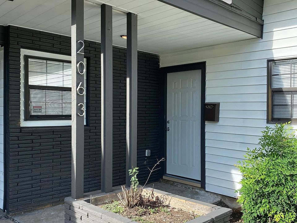 Freshly painted white exterior with gray trim and plenty of outdoor lighting.