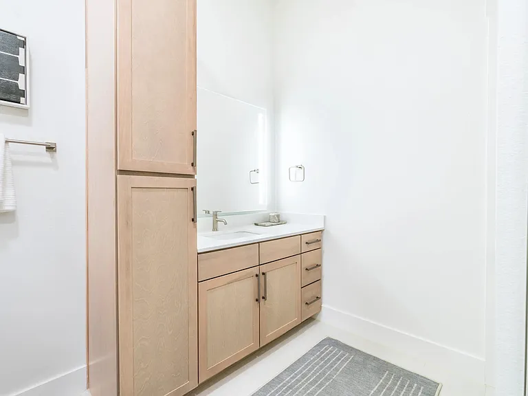 Designer bathrooms with quartz countertops and backlit mirrors*.