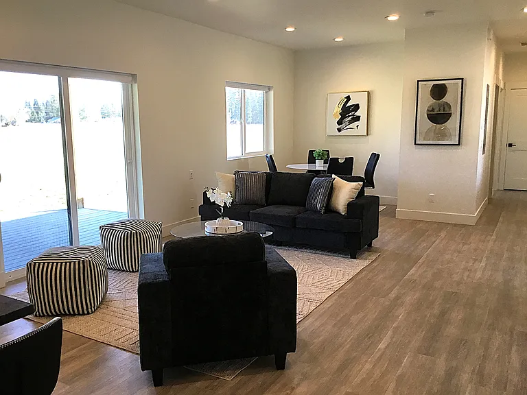 A warm and inviting open-concept design seamlessly connects the kitchen, dining area, and cozy sitting area. Just outside, the covered porch offers a peaceful place to relax and enjoy the breathtaking mountain views and surrounding natural beauty.