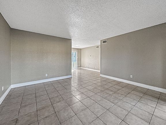 Bright, open-concept living room with neutral tones at Borders Apartments in Brownsville TX.