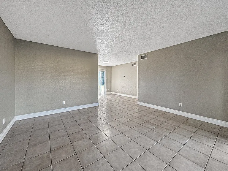 Bright, open-concept living room with neutral tones at Borders Apartments in Brownsville TX.
