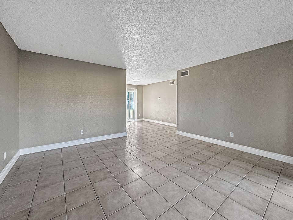 Bright, open-concept living room with neutral tones at Borders Apartments in Brownsville TX.