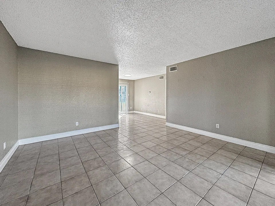 Bright, open-concept living room with neutral tones at Borders Apartments in Brownsville TX.