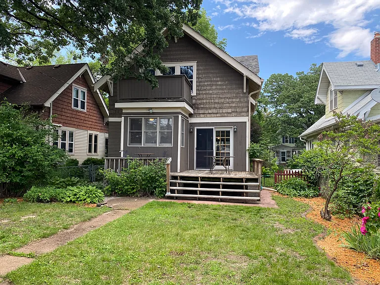 View of the back of the home with large main level deck and bonus upper-level private balcony off the rear bedroom!